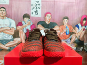 Front view of the pair showing the brown-black laces, textured toe boxes, and red patterned outsoles.