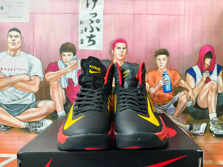 Pair of black Nike Kyrie basketball shoes with yellow accents and red trim, viewed from the front.