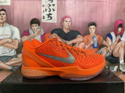 Side view of an orange basketball shoe with a silver Swoosh and sculpted sole.