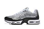Side view of white and black Nike sneakers with a dotted upper and visible air-cushion sole.