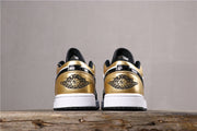 Rear pair view showing matching metallic gold heel panels, Jordan Wings branding, white midsoles, and black outsoles.