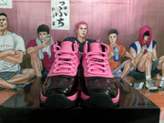 Front view of pink and black high-top sneakers with pink laces, glossy black toe overlays, and black outsoles.