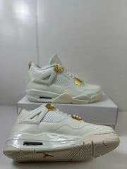 Low angled view of the white sneaker pair showing the outsole pattern, side profile, and gold-tone details.