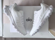White Alo sneakers arranged around a branded box.