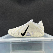 Side view of a white and cream low-top basketball shoe with black Swoosh and textured details