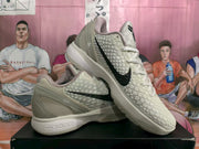 Angled view of the pair showing the cream textured uppers, black Swoosh details, padded collars, and low-top shape.