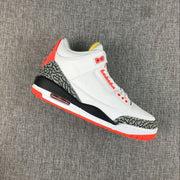 Angled side view of a white Jordan 3 sneaker with red accents and patterned overlays.