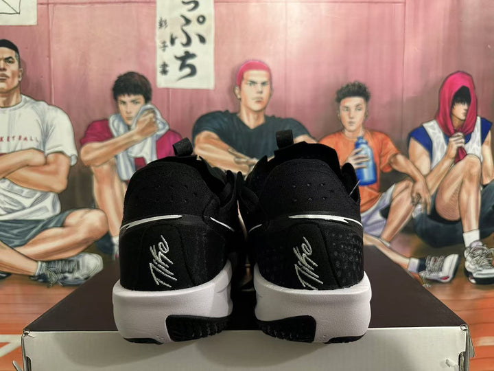 Rear view of black Nike basketball shoes with white midsoles and heel accents