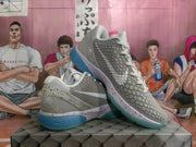 Side view of grey Nike basketball shoes with a speckled midsole and blue heel detail