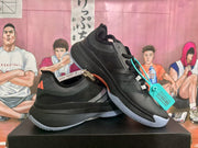 Pair of black Adidas shoes with white side stripes and light-colored outsoles, shown from the side.