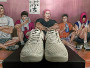 Front view of white Nike basketball shoes with textured uppers, white laces, and raised forefoot detailing.