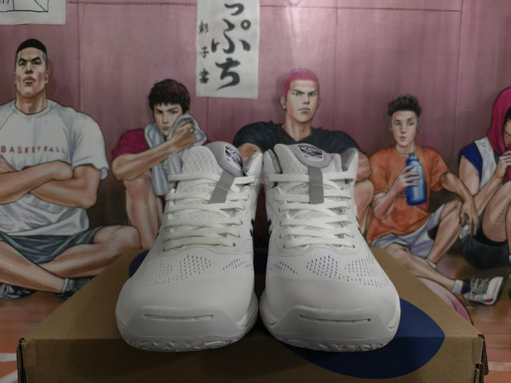 Front view of a pair of white ASICS basketball sneakers with dark blue accents and lace-up closures.