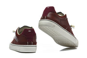 Burgundy low-top sneakers shown from the heel and outsole