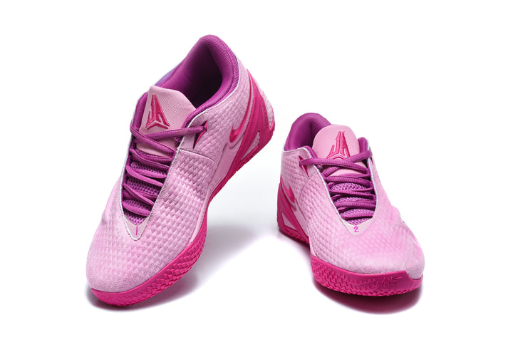 Pair of pink and magenta low-top basketball shoes shown from the front