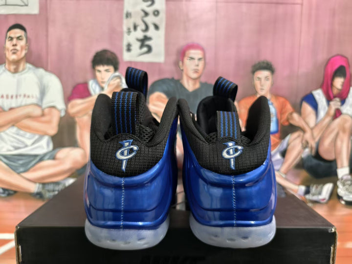 Rear view of blue and black high-top sneakers with pull tabs and light-colored soles