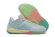 Side and outsole view showing the shoe’s translucent-looking sole with green, pink, and teal sections.