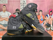 Angled side view of the grey and black high-top sneakers showing the padded collar, side mesh panel, cushioning window, translucent outsole, and attached hangtags.