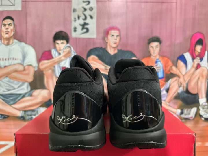 Rear view of black basketball sneakers showing glossy heel panels and signature-style detailing.
