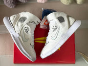 Top-down view of the white sneakers placed over a red box, showing both uppers and ankle straps.