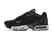 Side profile of a black Nike Air Max Plus TN sneaker with a white midsole and visible cushioning.