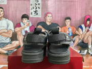Rear view of the black and gray sandals showing the heel straps, padded soles, and branding.