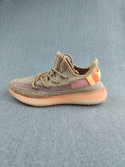 Single side-profile sneaker displaying the tan and mauve colorway with orange heel accents.