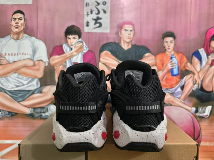 Rear view of black Nike sneakers showing padded collars, heel straps and white speckled midsoles with red details.