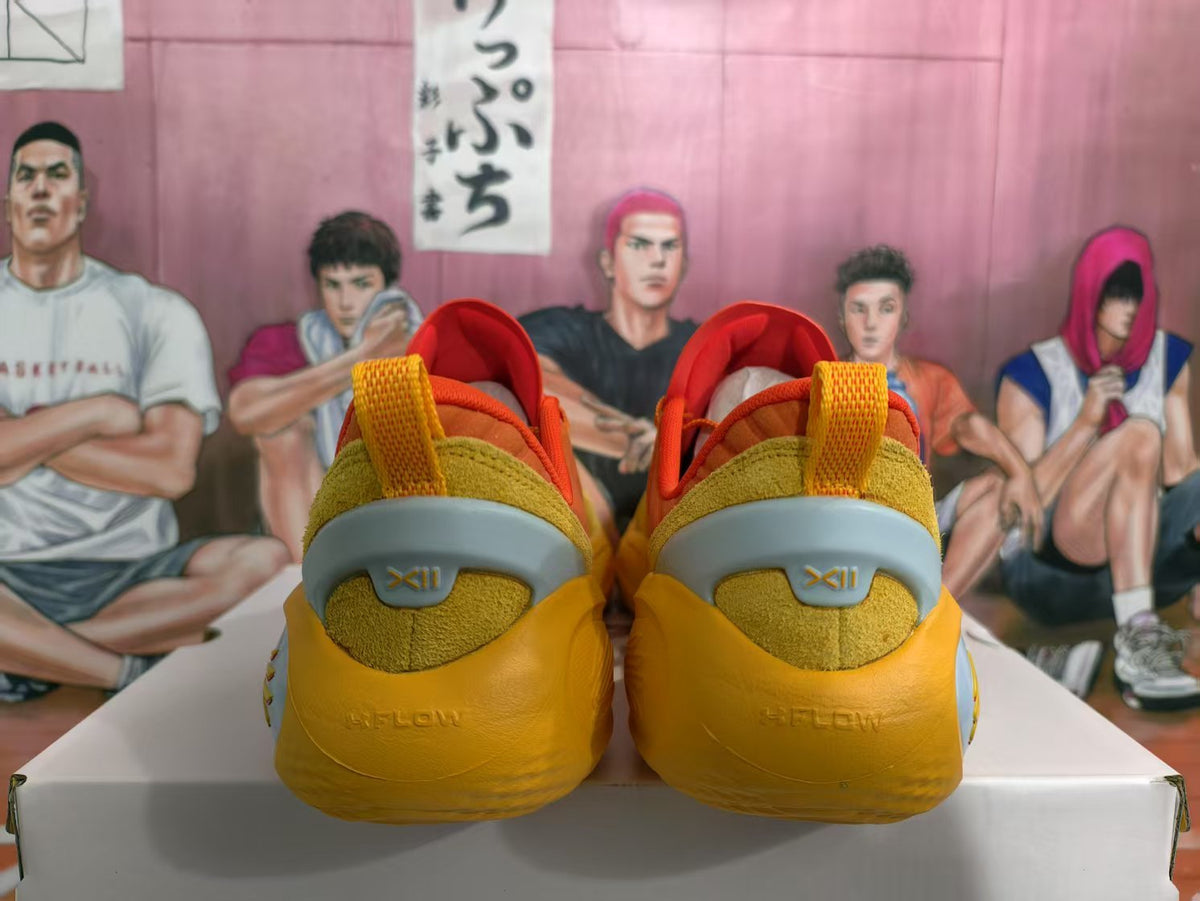 Rear view of orange Curry basketball shoes showing padded collars, textured heel panels and light gray heel accents.