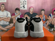Rear view of white and black Nike basketball sneakers showing perforated heel panels, black collars, and speckled midsoles.