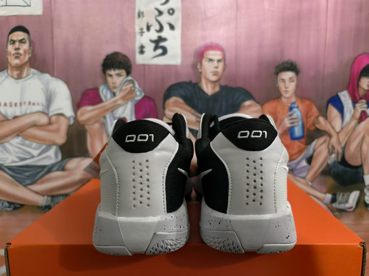 Rear view of white and black Nike basketball sneakers showing perforated heel panels, black collars, and speckled midsoles.