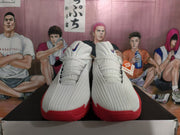 Front view of white ribbed basketball shoes with red outsole sections and blue tongue logos.
