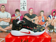 Side profile of a black, red, and gold Nike basketball sneaker with a visible Swoosh and LeBron marking.