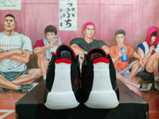 Rear view of the white, black, and red Jordan sneakers displayed on a black shoebox.