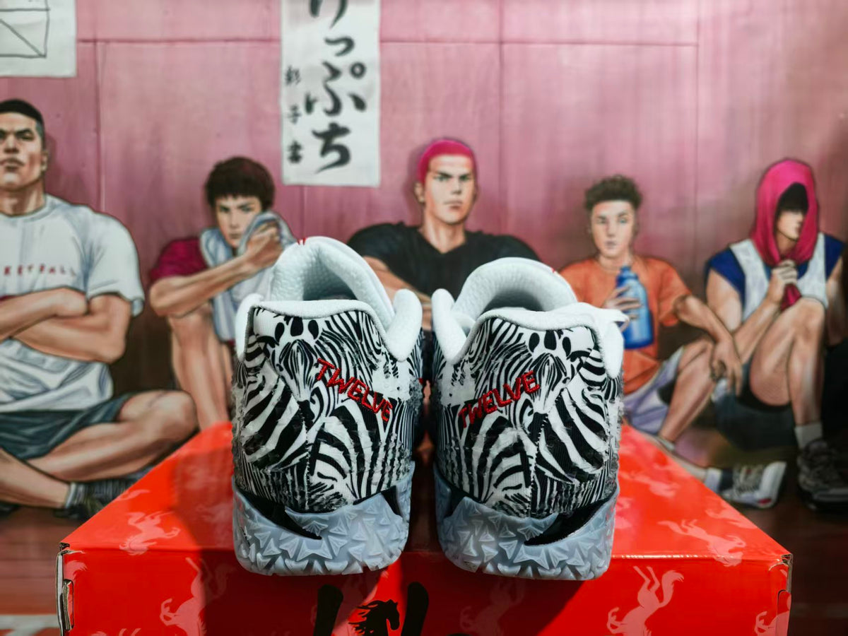 Rear view of zebra-print Nike basketball sneakers with white collars, red heel branding, and translucent textured outsoles.