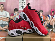 Angled view of the red, white, and black Nike sneakers displayed on a box.