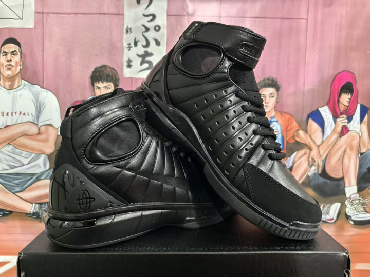Pair of black high-top basketball sneakers shown from the side on a shoe box.