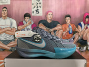Side view of a blue-gray Nike basketball shoe with a teal-accented Swoosh and circular emblem.