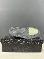 Outsole view of a Jordan Spizike Low sneaker showing a grey patterned rubber tread with a pale green circular forefoot section.