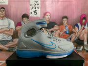 Side view showing the gray upper, blue Swoosh accent, ankle strap, and blue outsole