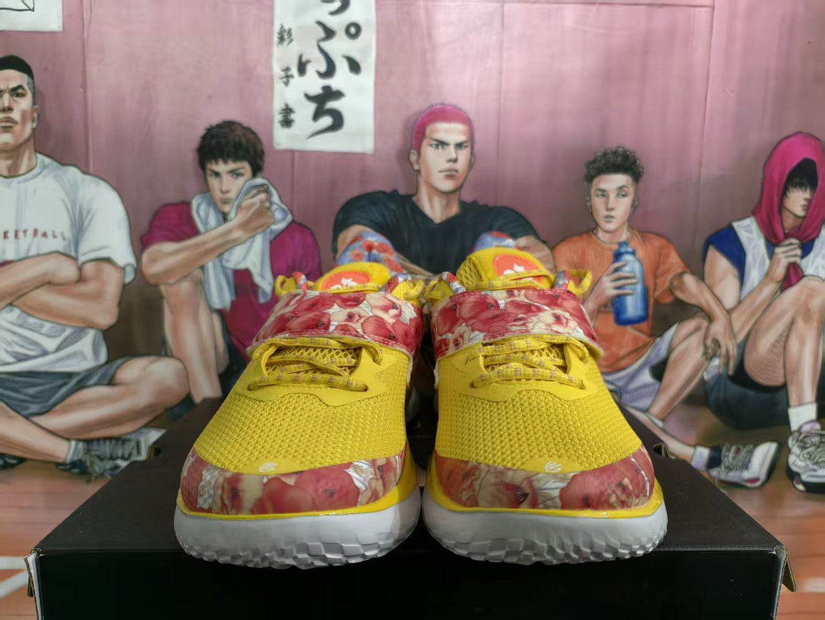 Front view of yellow basketball shoes with red floral-print panels and white soles