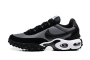 Side view of a black and grey low-top sneaker with a white midsole and lugged outsole.