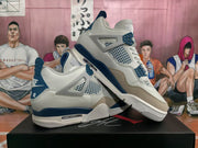 Angled view of white, blue, and grey Air Jordan 4 sneakers