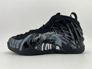 Black high-top sneaker with a glossy dark side panel and light graphic detailing.