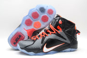 Black and grey Nike high-top basketball sneakers with orange laces, bright accents and a translucent outsole shown from the side.