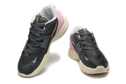 Charcoal, pink, and cream Nike Kyrie basketball shoes shown from the front