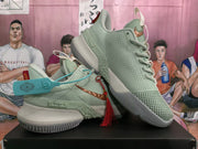 Angled view of the pale green Nike basketball sneakers showing the textured side panels, layered midsoles, outsole pattern, and decorative accessories.