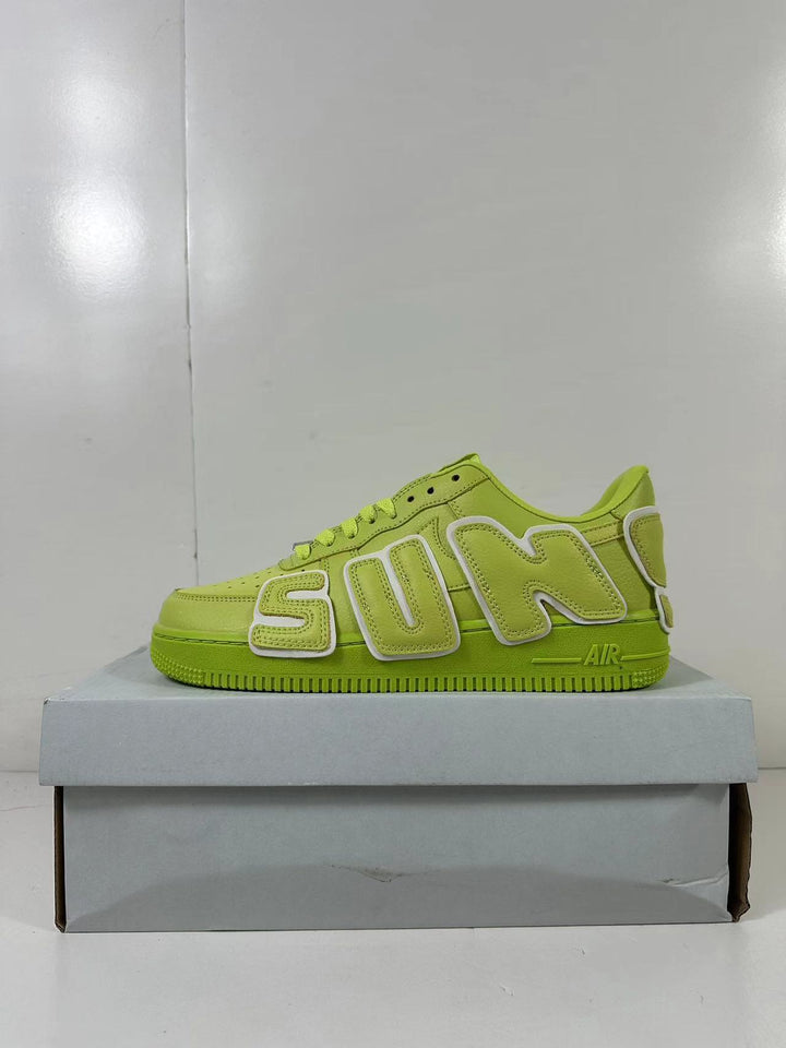 Green low-top sneaker shown in side profile on a shoebox, with large outlined side lettering.
