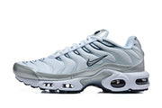 Side profile of pale blue-white and metallic silver Nike Air Max Plus sneakers with navy accents and visible sole cushioning windows.