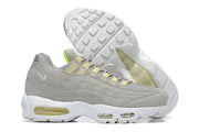 Gray Nike Air Max 95 sneaker beside its white tread outsole, showing visible air-unit windows.