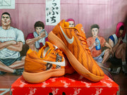 Angled view of the orange sneaker pair highlighting the animal graphics, side swoosh, and layered outsole.